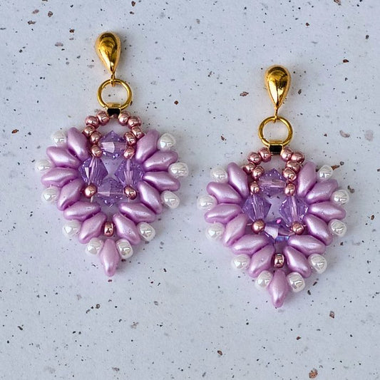Romantiske øreringe i hjerteform, vævet med rosa glasperler og funklende krystaller. Elegant og detaljeret design, perfekt til særlige anledninger