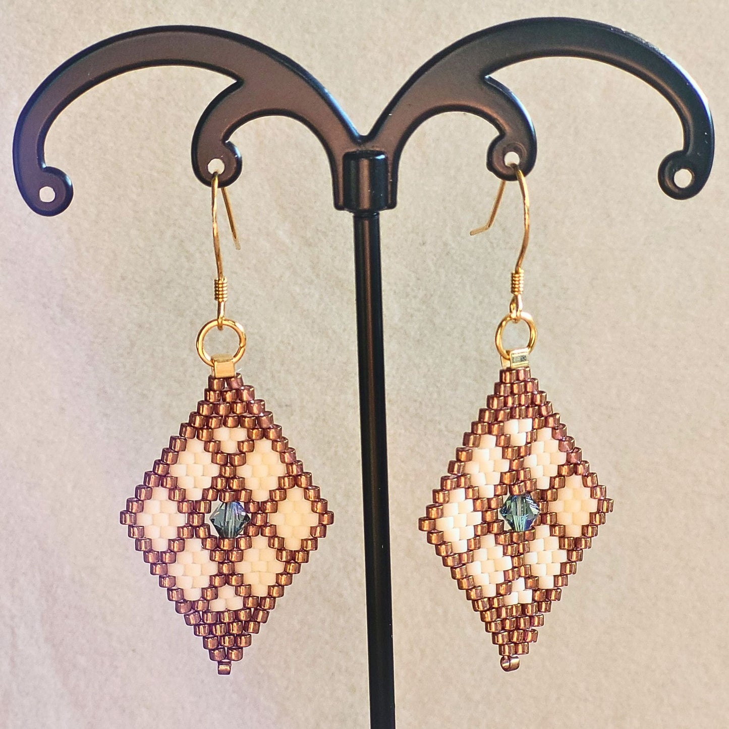Små håndvævede diamantformede øreringe i kobber og smør hvid nuancer – elegante Miyuki-perler i geometrisk mønster med diskret glans