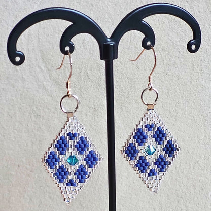 Små håndvævede diamantformede øreringe i blå og solv nuancer – elegante Miyuki-perler i geometrisk mønster med diskret glans