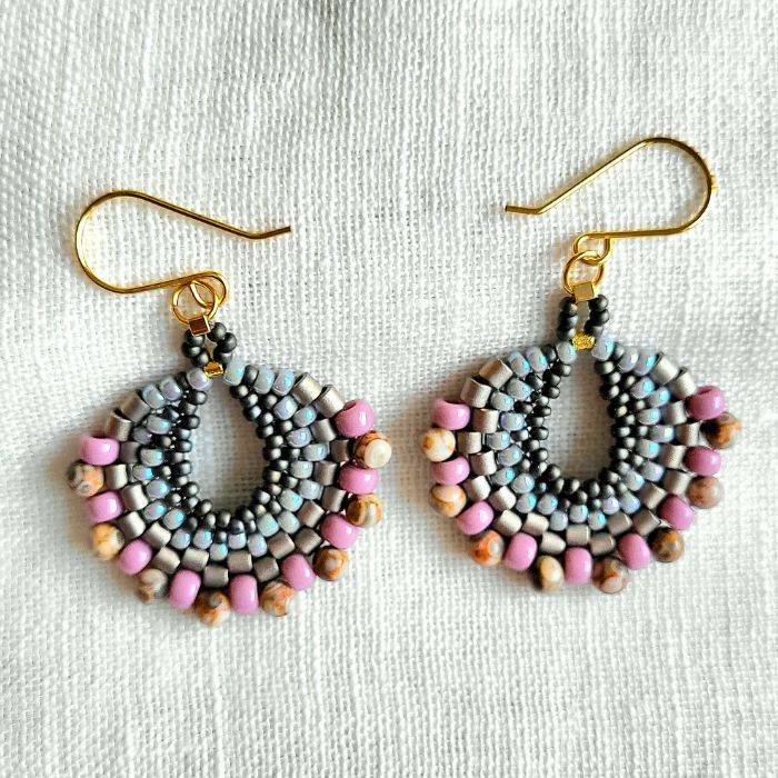 Håndlavede halvmåneformede øreringe i grå, sølv og pink – bohemeinspireret design med perler i lag og let bevægelse.