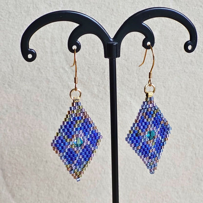 Små håndvævede diamantformede øreringe i blå nuancer – elegante Miyuki-perler i geometrisk mønster med diskret glans