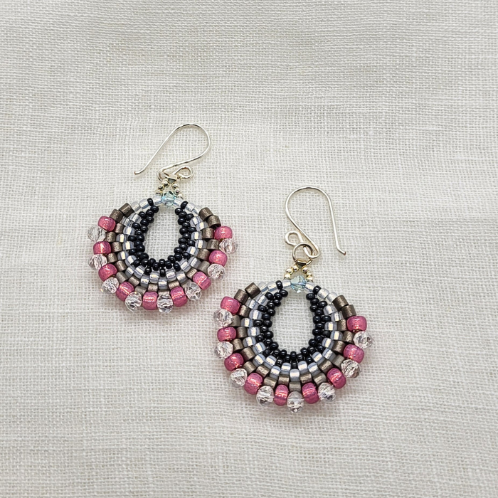 Håndlavede halvmåneformede øreringe i sort, sølv og pink – bohemeinspireret design med perler i lag og let bevægelse.